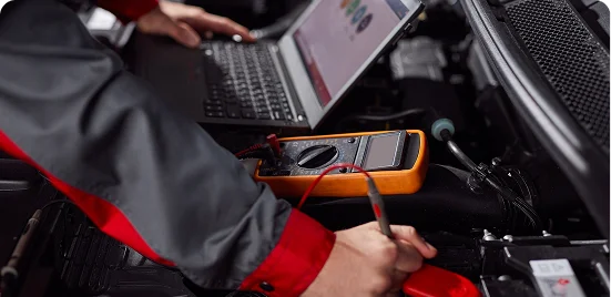 Técnico utilizando scanner e notebook para diagnóstico do motor